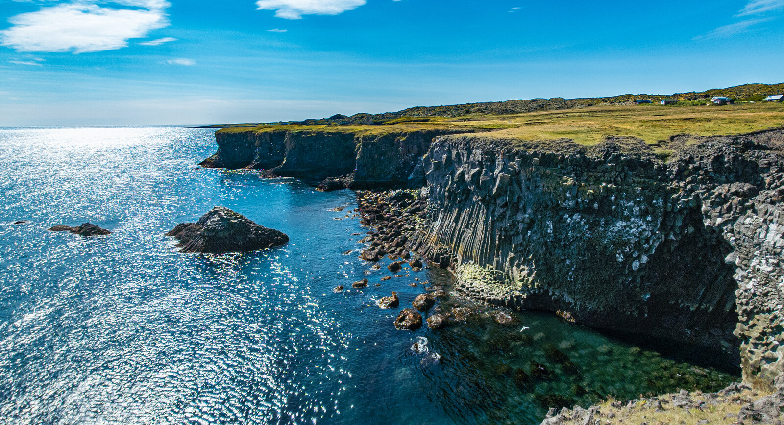 Basalt sea cliffs and turquoise water along the Arnarstapi coast on Snæfellsnes